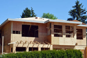 A house under construction with scaffolding and a roof, labeled as ADU Construction.