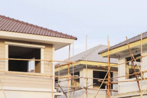 . Under construction house featuring scaffolding and a roof, identified as ADU Construction.